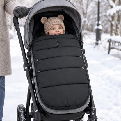 Bébé bien au chaud dans la chancelière Boréal sur une poussette, dans un parc enneigé
