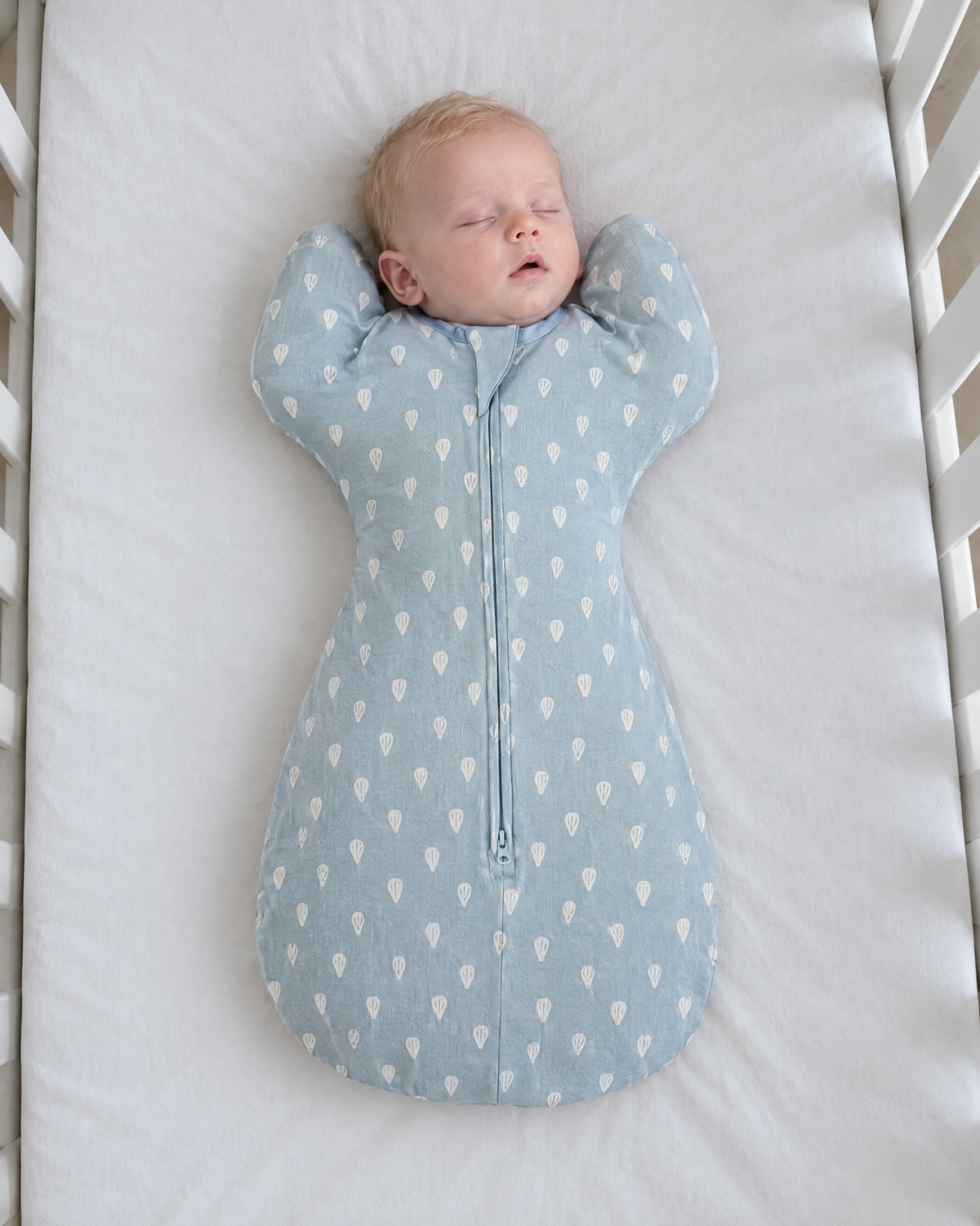 Bébé endormi dans la gigoteuse bras levés Boréal motif gouttes bleues
