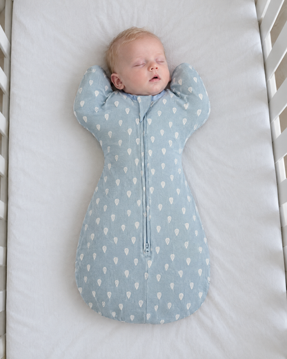 Bébé endormi dans la gigoteuse bras levés Boréal motif gouttes bleues
