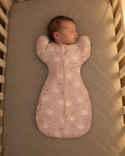 Bébé endormi dans la gigoteuse bras levés Boréal motif cygnes rose